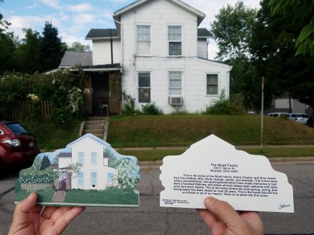 Holding up the Cat's Meow heirloom replica of the Wyatt home in front of the actual home.