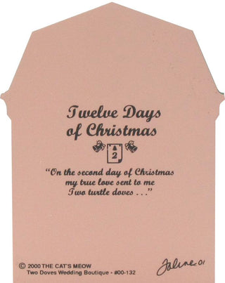 A peach-colored wedding keepsake card shaped like a tombstone, featuring black printed text that reads 'Twelve Days of Christmas' with a small Christmas card and gifts illustration, a quote, and signatures at the bottom.
