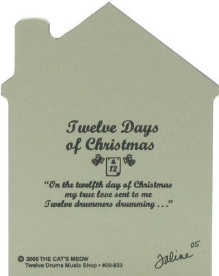 wooden replica with a  muted sage green background that features the text 'Twelve Days of Christmas' and a quote from 'The Cat's Meow' album, with a small calendar icon and decorative script.