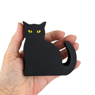 3/4" thick wooden Black cat-shaped object held in a hand against a white background