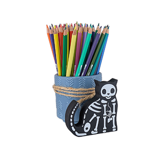 3/4" thick wooden cat-shaped skeleton sitting in front of a pencil holder with colorful pencils on a white background
