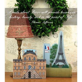 Decorative items with Paris-themed cutouts and a lamp on a textured surface.