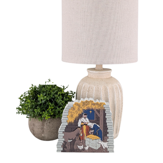 3/4" thick wooden illustration of a nativity scene on a white background with lamp and plant