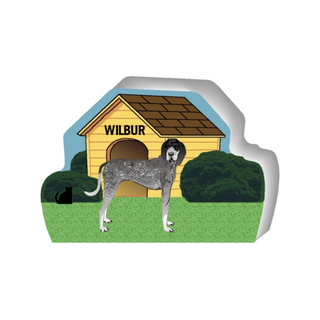 wooden replica of a illustrated gray with white and brown spots dog standing in front of a dog house