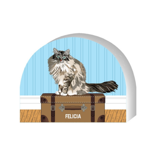 Wooden replica of a  Illustration of a cat named Felicia sitting on a suitcase with a blue wall in the background.