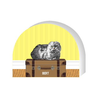 Wooden replica of a  Cat on a suitcase with a yellow wall in the background