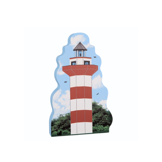 3/4" thick wooden  cutout of a lighthouse with a blue sky and trees in the background