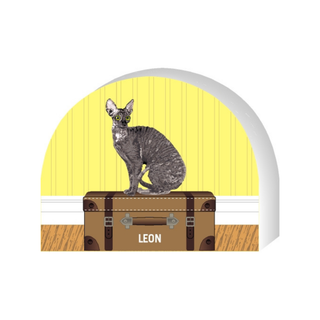 Wooden replica of a illustration of a cat named 'Leon' on a suitcase with a yellow background