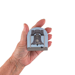 3/4" thick wooden cutout  of the Liberty Bell with a cat sitting below on a light blue background