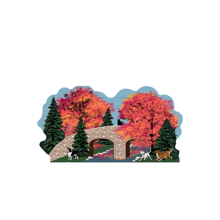 3/4" thick wooden Illustration of a stone bridge with trees in autumn colors and three dogs on a path.