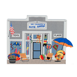 wooden replica with an illustration of dr. gravity's kite shop with toys and flags in the windows