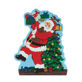 3/4" thick wooden replica with an Illustration of A festive Christmas-themed silhouette-shaped decoration featuring Santa Claus carrying a teddy bear and reaching for wrapped gifts next to a decorated Christmas tree, with toy vehicles at the base, shown on a plain white background.
