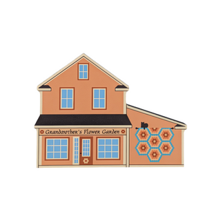 3/4" thick wooden illustration of a orange house with a quilt