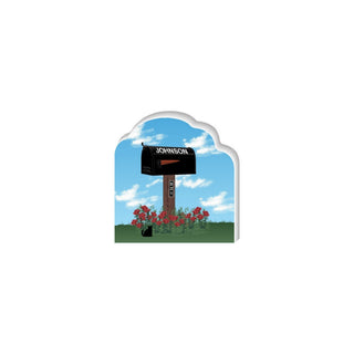 Wooden 3/4" Replica Mailbox with 'JOHNSON' on a wooden post, surrounded by red flowers and a black cat under a blue sky.