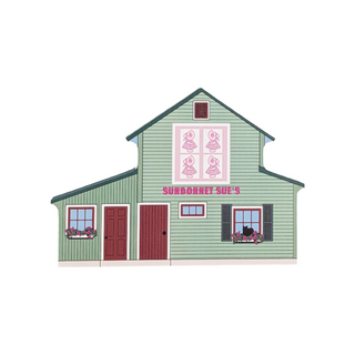 3/4" thick wooden illustration of a green building with a quilt