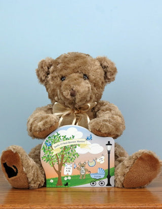 Brown stuffed teddy bear holding a wooden baby announcement 