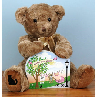 Brown stuffed teddy bear holding a wooden baby announcement 