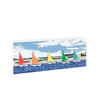 decorative wooden replica with colorful sailboats on a blue water background