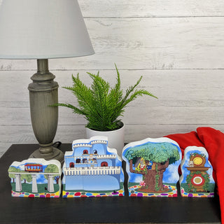 Decorative pieces on a table with a lamp and plant in the background
