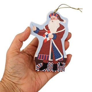 Hand holding a decorative ornament shaped like a traditional Santa Claus figure with a white beard.