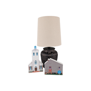Decorative lamp with two small model houses on a white background