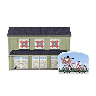 3/4" thick wooden illustrations of a model of a barn with quilt-style design on the doors, featuring a bicycle in the foreground.