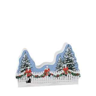 3/4" thick wooden replica with an illustration of a Christmas scene with trees, a picket fence, and bows on a white background