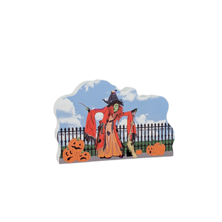 wooden replica with Halloween-themed witch, pumpkins, and a fence on a white background