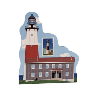 Wooden replica featuring a lighthouse and keeper's cottage illustration, with a postage stamp design of the same lighthouse shown near the center on a plain white background.