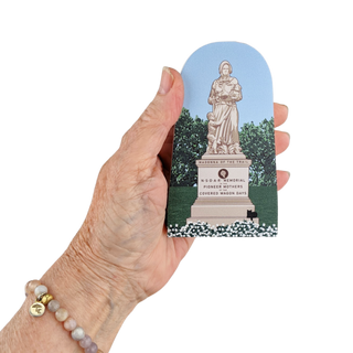 Hand holding a 3/4" thick model with a statue design on a white background
