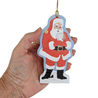 Hand holding a Christmas ornament with a Santa Claus design on a white background