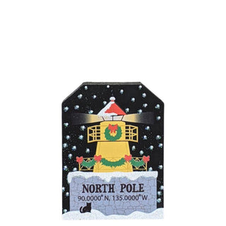 3/4" thick wooden replica with an illustration of a  lighthouse, wreath, and Santa hat on a snowy background.