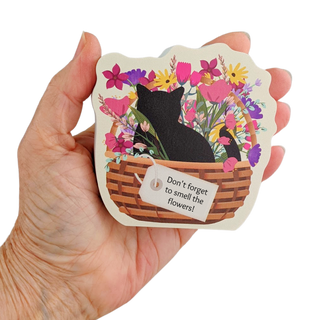 Hand holding a 3/4" thick wooden cutout with a cat and floral design.