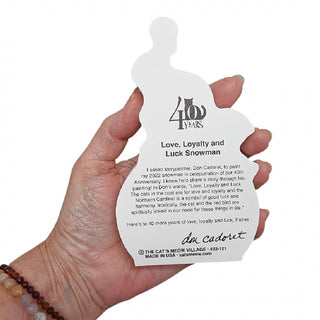 A hand holding the back of a product with  black printed text and a '400 Years' logo, with a visible signature at the bottom.