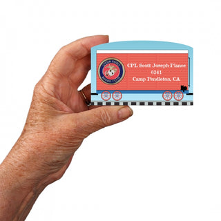 Hand holding a 3/4" Wooden replica with a miniature train car with a personalized message on a white background