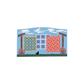 3/4" thick wooden illustration of quilts hanging on a clothesline against a blue sky.