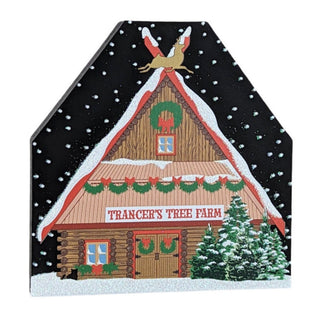 3/4" thick wooden replica with an illustration of a  cabin named 'Trancer's Tree Farm' with Christmas decorations on a black background.