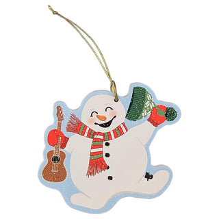 A snowman-shaped Christmas ornament with a gold hanging string, featuring a smiling snowman wearing a red and green striped scarf, holding a brown ukulele and a green tree, on a plain white background.