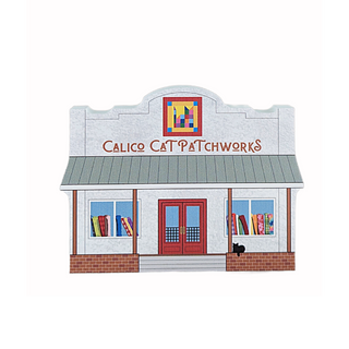 3/4" thick wooden illustration of a storefront with 'Calico Cat Patchworks' sign and quilt displays