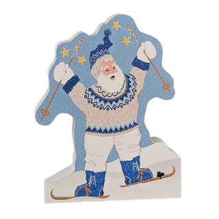3/4" thick wooden replica with an Illustration of a winter Santa skier standing in the snow, with a light blue snowy background, gold stars, and a multicolor sweater and boots design.