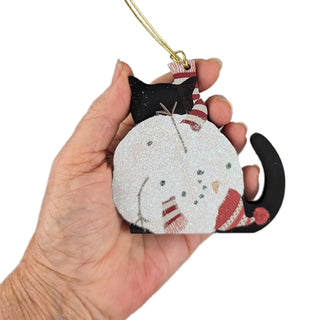 wooden ornament with a black cat and a crumpled up snowman with red had 