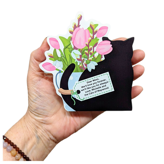 Hand holding wooden model of a black cat with tulips and flowers with a tag that is personalized with names