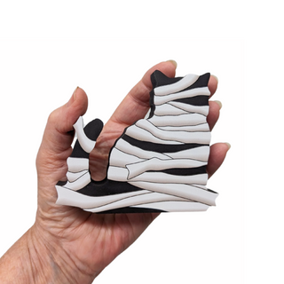 Hand holding a 3/4" thick wooden mummy against a white background