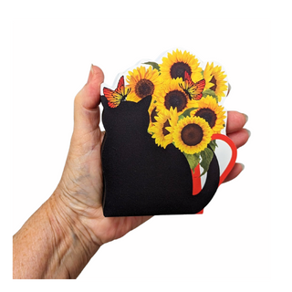 Hand holding a black cat-shaped 3/4" thick wooden cutout with sunflowers and butterflies on a white background