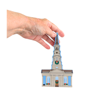 3/4" thick wooden illustration of a church with a hand holding it