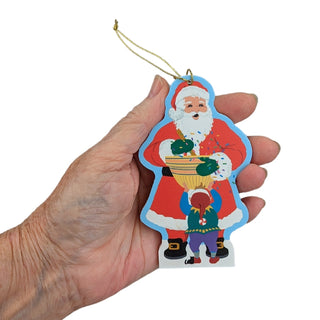 Hand holding a Christmas ornament with Santa Claus design on a white background
