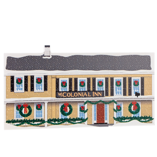 Decorative wooden replica of a building facade with wreaths and 'Colonial Inn' sign.