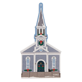 wooden replica with an illustration of a church with steeple with snow and christmas decorations on it