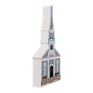 wooden replica with an illustration of a church with steeple with snow and christmas decorations on it