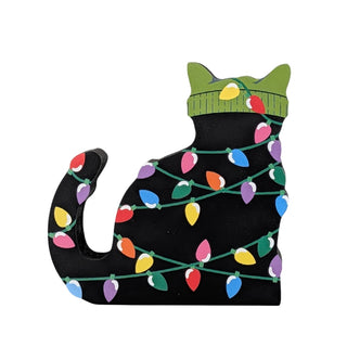 3/4" thick wooden replica of a black cat with a green beanie on all tangled up in christmas lights